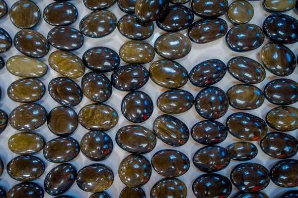 Close up of shinny natural mineral stone - black obsidian gemstone from Mexico over a table inside of a souvenir store — Stock Photo, Image