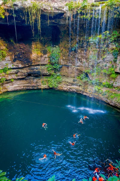 CHICHEN ITZA, MÉXICO - NOVEMBRO 12, 2017: Pessoas não identificadas nadando em Ik-Kil Cenote perto de Chichen Itza, México. Adorável cenote com águas transparentes e raízes penduradas — Fotografia de Stock