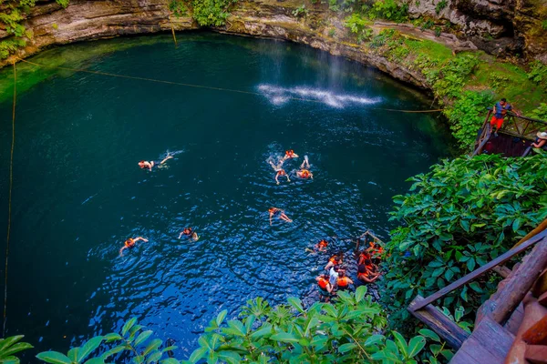 치첸이트사, 멕시코-11 월 12 일, 2017: 정체 불명된 사람들 Ik Kil Cenote 치첸이트사, 멕시코 근처에서 수영. 투명 한 바다와 아름 다운 cenote 즐기고 있고 뿌리에 매달려 — 스톡 사진