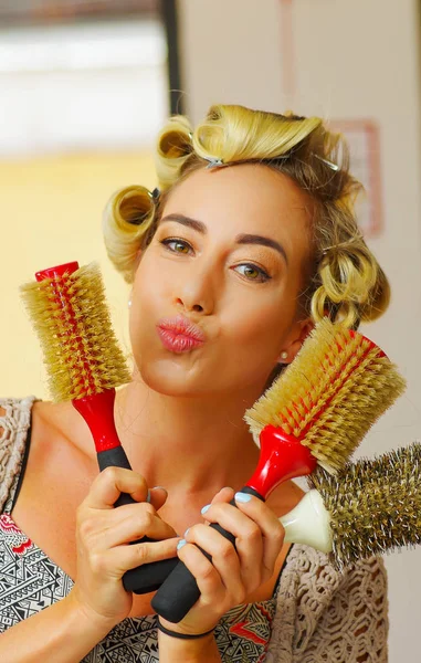 Porträtt av kvinna på frisören, hålla i hennes händer många runda penslar, i frisersalong — Stockfoto