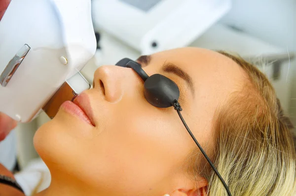 Portret van arts met een laser ontharing via een snor van de vrouw, in een onscherpe achtergrond — Stockfoto
