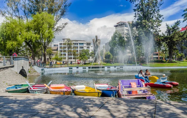 QUITO, ECUADOR - JANEIRO 31, 2018: Pessoas não identificadas em barcos que apreciam o dia ao redor da lagoa no Parque La Alameda com alguns edifícios em segundo plano. Este é o parque mais antigo da cidade de — Fotografia de Stock