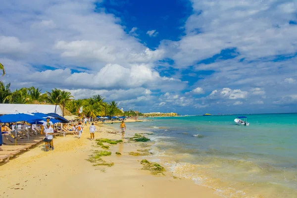 Playa del Carmen, México - 10 de enero de 2018: Personas no identificadas sentadas bajo una sombrilla y disfrutando de la playa en Playa del Carmen al atardecer — Foto de Stock