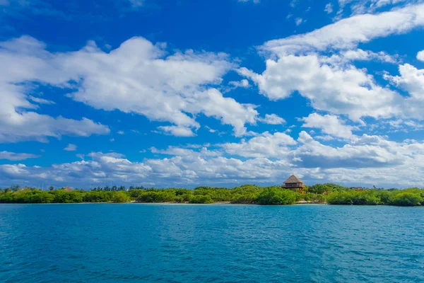 Hermoso paisaje de bosque verde y una hermosa casa de madera en el horizonte en la playa Isla Mujeres en el mar Caribe, con un agua turquesa en México — Foto de Stock