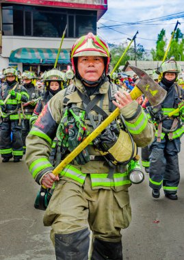 Quito, Ekvator - 31 Ocak 2018: Tanımlanamayan grup Quito içinde geçit töreni sırasında sokaklarda yürüyüş proitection, tam bir ekipman giyen itfaiye takımının