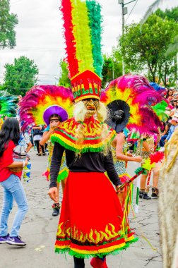 Quito, Ekvator - 31 Ocak 2018: Açık renkli kostümleri giyen ve Quito festivaller şehir geçit töreni sırasında sokaklarda yürüyüş kimliği belirsiz kişi görünümünü
