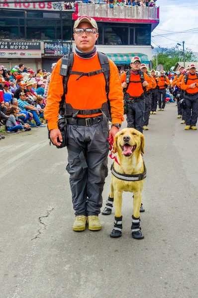 厄瓜多尔基多-2018年1月31日: 在厄瓜多尔基多游行期间, 一只漂亮的金色猎犬狗, 一组救援人员在街上散步的身份不明男子的户外视野 — 图库照片