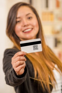 Güzel bir gülümseyen womans kartvizit Qr kodu bilgileriyle bulanık bir arka planda gösterilen, yakın çekim