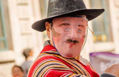 Quito, Ekvator - 11 Ocak 2018: Bir şapka ve maskesi giyen ve Quito, Ekvator kentinde bir geçit töreni sırasında sokaklarda yürüyüş kimliği belirsiz kişi portresi