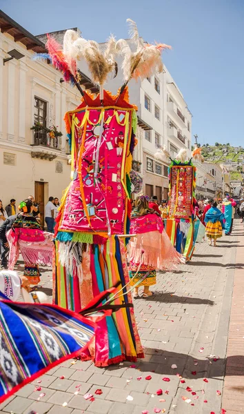 厄瓜多尔基多-2018年1月11日: 在厄瓜多尔基多举行的游行中, 不明身份的人穿着五颜六色的衣服戴着羽毛, 在街上跳舞的户外景色 — 图库照片