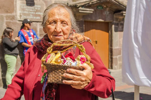 Quito, Ecuador - 11 januari 2018: Närbild av gamla kvinna som håller i hennes händer en halm korg med lite hantverk, under en parad i Quito, Ecuador — Stockfoto