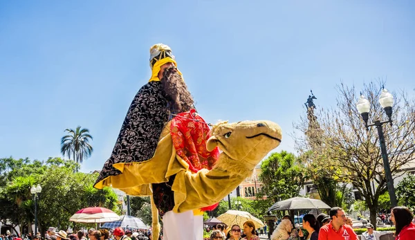Quito, Ecuador - 11 januari 2018: Close-up van ongeïdentificeerde man dragen van een kostuum van wijze mannen een nep kameel rijden en wandelen in de straten tijdens een parade in de stad van Quito, Ecuador — Stockfoto