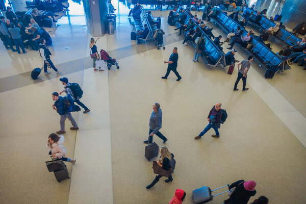 LOS ANGELES, EEUU, JANUARY, 29, 2018: Above view of unidentified people sitting in the chairs waiting inside of the airport for departure flights, of the Los Angeles International Airport LAX , the