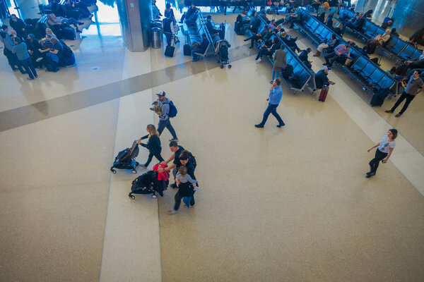 ЛОС-АНДЖЕЛЕС, EEUU, ЯНВАРЬ, 29 января 2018 года: Неизвестные люди, сидящие в креслах в ожидании вылета рейсов, Лос-Анджелесского международного аэропорта LAX, основного аэропорта
