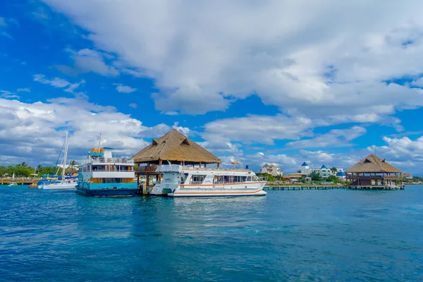 ISLA MUJERES, MÉXICO, 10 DE ENERO DE 2018: Vista exterior del barco en la costa con muchos pasajeros, cerca de una casa típica de la Isla Mujeres. La isla tiene unos 7 kilómetros de largo y 650 metros de ancho — Foto de Stock