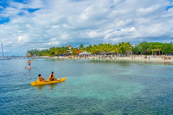 Cancún, Mexico - 10 januari 2018: Oidentifierade personer paddling i deras kayack i en vacker karibiska stranden isla mujeres med ren och öppet vatten i Mexiko, sol och palmer. Turism-konceptet — Stockfoto