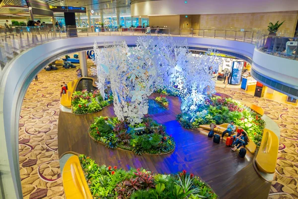 SINGAPOUR - CIRCA AOÛT 2016 : Vue ci-dessus de personnes non identifiées assises dans un petit jardin avec des plantes à l'intérieur de l'aéroport Changi de Singapour. Singapour Changi Airport est le principal civil — Photo