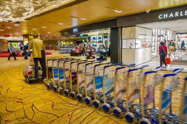 Singapur, Singapur - 30. ledna. 2018: Unidentifiedman vozí mnoho zavazadel vozíky, které jsou nastaveny v pořadí pro odběratele v mezinárodní letiště Singapore Changi — Stock fotografie