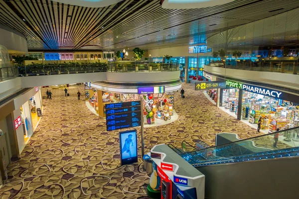 SINGAPORE, SINGAPORE - 30 GENNAIO 2018: Sopra la vista di cartelli informativi, negozi, scale elettriche e persone che camminano all'interno dell'aeroporto internazionale di Singapore Changi — Foto Stock