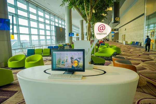 SINGAPUR, SINGAPUR - 30 DE ENERO DE 2018: Cierre de una computadora para usar y verificar salidas en interiores en sala de espera dentro del aeropuerto internacional de Changi — Foto de Stock