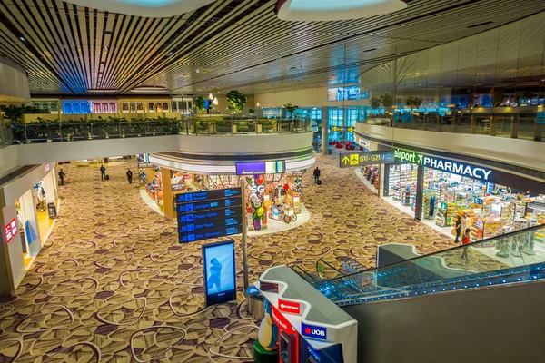 SINGAPUR, SINGAPUR - 30 DE ENERO DE 2018: Sobre la vista de los letreros informativos, tiendas, escaleras eléctricas y personas que caminan dentro del Aeropuerto Internacional de Singapur Changi — Foto de Stock
