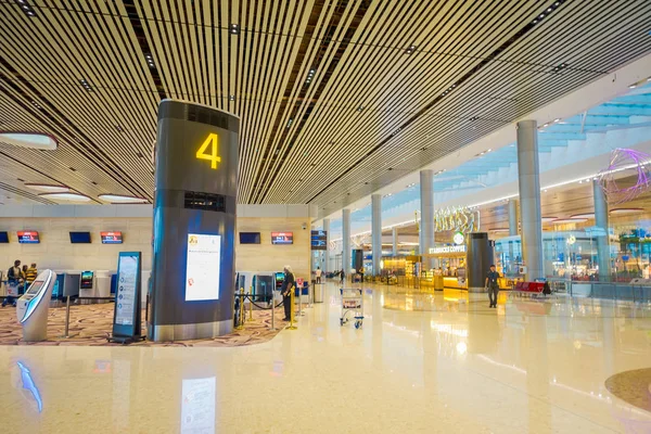 SINGAPUR, SINGAPUR - 30 DE ENERO DE 2018: Vista interior de personas no identificadas caminando cerca de una puerta de salida número 4 de pie cerca de un quiosco de auto check-in en el aeropuerto de Singapur Changi —  Fotos de Stock