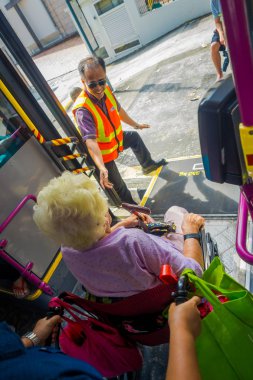 Singapore, Singapur - 01 Şubat 2018: Bir tekerlekli sandalye otobüs ve bir hnad, toplu taşıma Singapur içinde veren otobüs şoförü bırakarak, tanımlanamayan yaşlı kadın