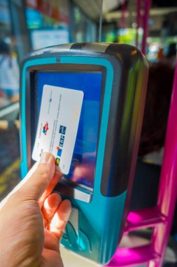 Singapore, Singapur - 01 Şubat 2018: Singapur toplu taşıma için ödeme için bir kart kullanan bir kişi, kapalı görünüm