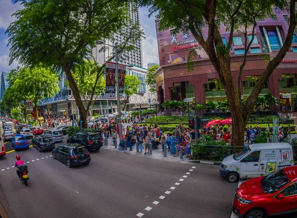 SINGAPORE, CINGAPORE - JANEIRO 30. 2018: Vista ao ar livre da multidão de pessoas andando nas ruas perto de um tráfego pesado nas ruas da cidade em um condomínio residencial público — Fotografia de Stock