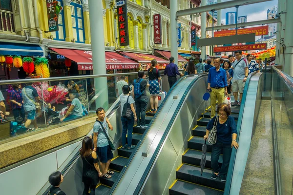 SINGAPUR, SINGAPUR - 30 DE ENERO DE 2018: Personas no identificadas que usan escaleras eléctricas en la bulliciosa calle del distrito de Chinatown en Singapur. Singapores Chinatown es una famosa tienda de gangas — Foto de Stock