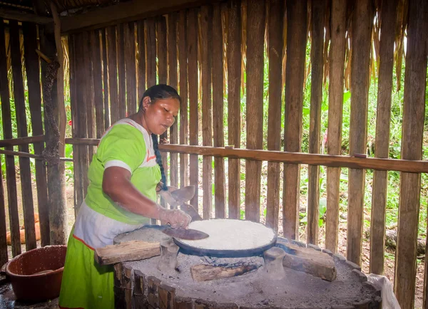 LAGO AGRIO, ECUADOR - 17 NOVEMBRE 2016: Donna dimostra tortillas di yucca in una cucina al chiuso in un villaggio di Siona nella riserva naturale di Cuyabeno, Ecuador — Foto Stock