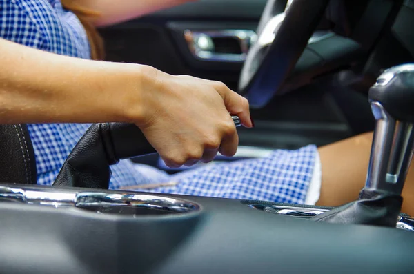 Fechar o foco seletivo da mão da mulher acionando um freio de mão dentro de seu carro, de pé na lateral — Fotografia de Stock
