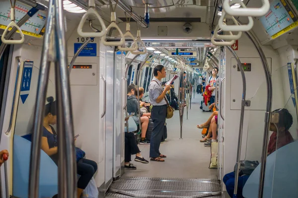 SINGAPORE, SINGAPORE - JANUARY 30, 2018: Indoor view of people in a rail commuters ride a crowded Mass Rapid Transit MRT train through the city centre, has a daily ridership of 2.8 million passengers — Stock Photo, Image