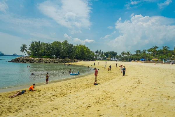 SINGAPUR, SINGAPUR - 01 DE FEBRERO DE 2018: Personas no identificadas disfrutando de la arena amarilla y nadando en la playa tropical en sentosa, Singapur — Foto de Stock