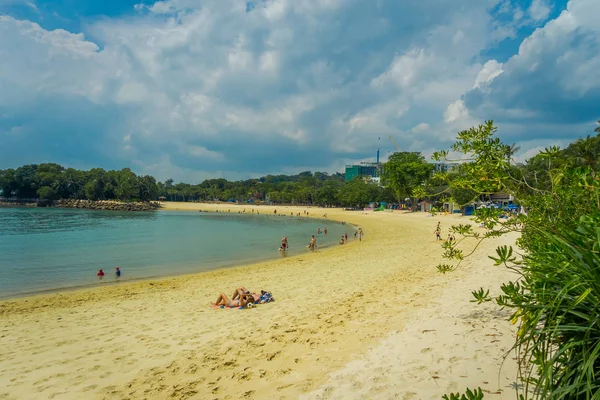 Hermosa vista al aire libre de personas no identificadas disfrutando de la arena amarilla y la playa tropical en sentosa, Singapur — Foto de Stock