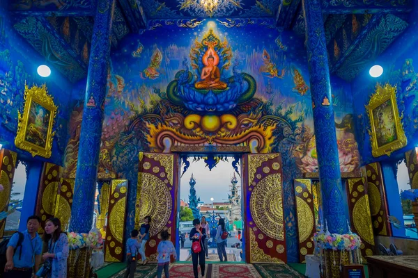 CHIANG RAI, TAILANDIA - 01 DE FEBRERO DE 2018: Personas no identificadas en la entrada del templo en Wat Rong Suea Ten, con hermosos colores y pinturas en el techo, paredes dentro del templo azul —  Fotos de Stock