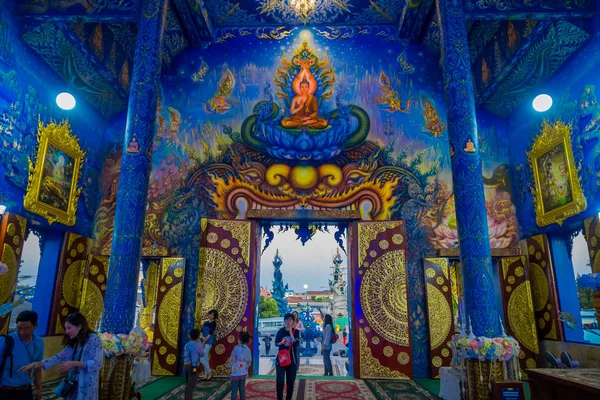 CHIANG RAI, TAILANDIA - 01 DE FEBRERO DE 2018: Personas no identificadas en la entrada del templo en Wat Rong Suea Ten, con hermosos colores y pinturas en el techo, paredes dentro del templo azul — Foto de Stock