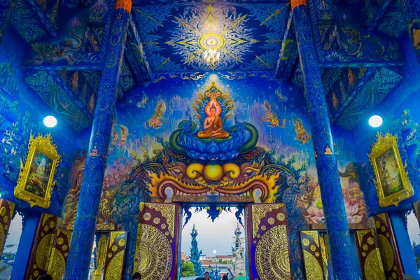 CHIANG RAI, TAILANDIA - 01 DE FEBRERO DE 2018: Personas no identificadas en la entrada del templo en Wat Rong Suea Ten, con hermosos colores y pinturas en el techo, paredes dentro del templo azul —  Fotos de Stock