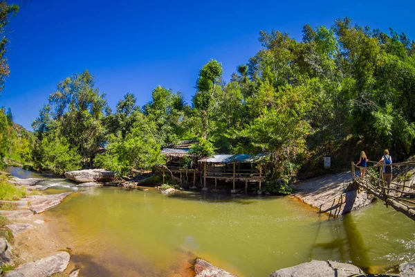 CHIANG RAI, TAILANDIA - 01 DE FEBRERO DE 2018: Vista al aire libre de personas no identificadas caminando en la selva tropical utilizando un puente de madera, cruzando un pequeño río en la provincia de Chiang Mai, Tailandia —  Fotos de Stock