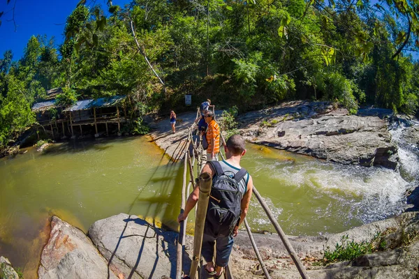 チェンライ、タイ - 2018 年 2 月 1 日: 不明の人がチェンマイ、タイの小さな川を越えて木製の橋を使用して熱帯雨林ウォーキング屋外観 — ストック写真