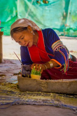 Chiang Rai, Tayland - 01 Şubat 2018: Kimliği belirsiz kadın bambu kamışı uzun boyunlu tepe kabile Köyü Chiang Mai Kayan Lahwi ile bir handycraf yapmak için bir bıçak kullanarak açık görünümünü