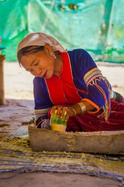 Chiang Rai, Tayland - 01 Şubat 2018: Kimliği belirsiz kadın bambu kamışı uzun boyunlu tepe kabile Köyü Chiang Mai Kayan Lahwi ile bir handycraf yapmak için bir bıçak kullanarak açık görünümünü