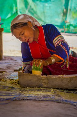 Chiang Rai, Tayland - 01 Şubat 2018: Kimliği belirsiz kadın bambu kamışı uzun boyunlu tepe kabile Köyü Chiang Mai Kayan Lahwi ile bir handycraf yapmak için bir bıçak kullanarak açık görünümünü