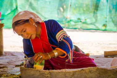 Chiang Rai, Tayland - 01 Şubat 2018: bambu kamışı uzun boyunlu tepe kabile Köyü Chiang Mai Kayan Lahwi ile bir handycraf yapmak için bir bıçak kullanarak kimliği belirsiz kadın