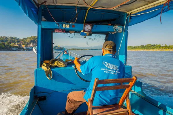 CHIANG RAI, THAILAND - FEBRUARY 01, 2018: Outdoor view of the captain in the cabin sailing a boat in the waters of port at golden triangle Laos — Stock Photo, Image