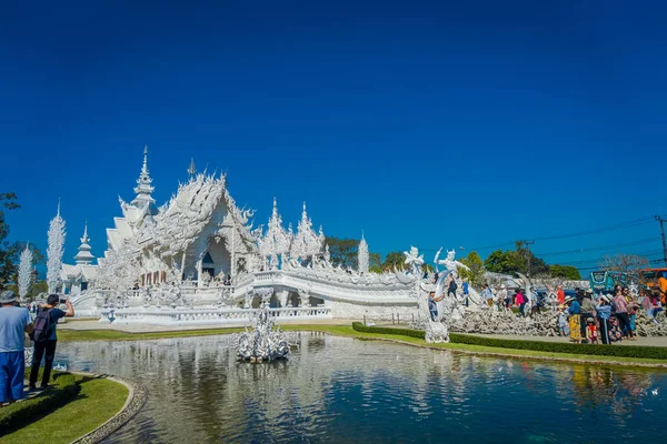 CHIANG RAI, THAILAND - FEBRUARY 01, 2018: Unidentified people visiting the beautiful white church of Wat Rong Khun temple in Chiangrai, Thailand, reflected in the water — Stock Photo, Image