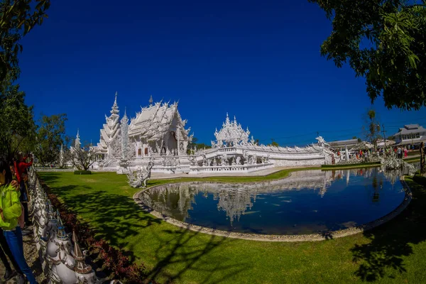 CHIANG RAI, THAILAND - FEBRUARY 01, 2018: Unidentified people taking pictures to white temple Wat Rong Khun located in Chiang Rai northern Thailand in sunny day with a natural pond — Stock Photo, Image