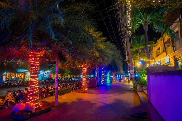 AO NANG, THAÏLANDE - 09 FÉVRIER 2018 : Vue extérieure de pople non identifiés marchant sur un trottoir près de nombreux magasins et d'un palmier rempli de lumières de Noël dans la rue Ao Nang pendant la nuit dans AO — Photo