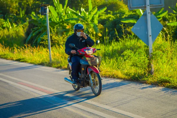 CHIANG RAI, THAÏLANDE - 01 FÉVRIER 2018 : Un homme non identifié utilisant un casque de protection et conduisant une moto est le transport le plus populaire en Asie du Sud, à Chiang Mai, Thaïlande — Photo