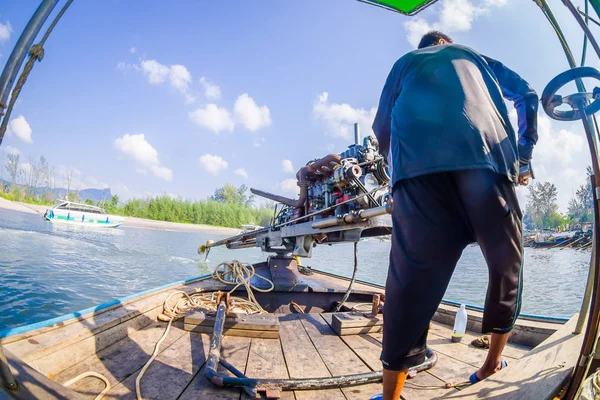AO NANG, TAILANDIA - 09 DE FEBRERO DE 2018: Un hombre no identificado manipula un motor de barco con un fondo de naturaleza borrosa —  Fotos de Stock